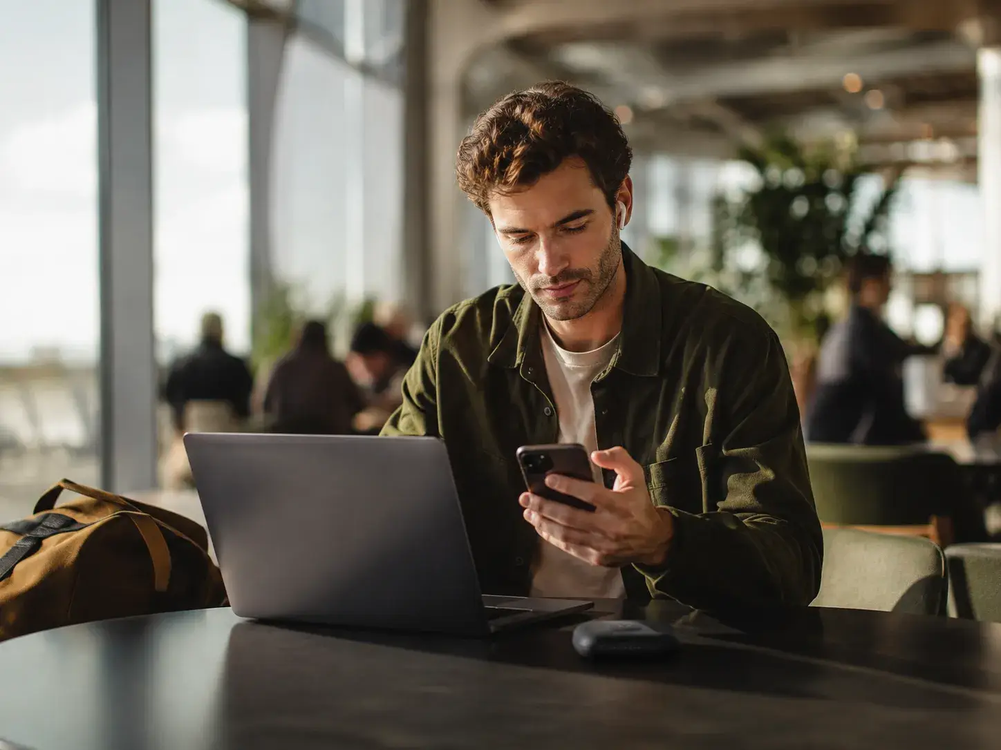 Man gebruikt laptop en smartphone onderweg met een mobiele internetverbinding.